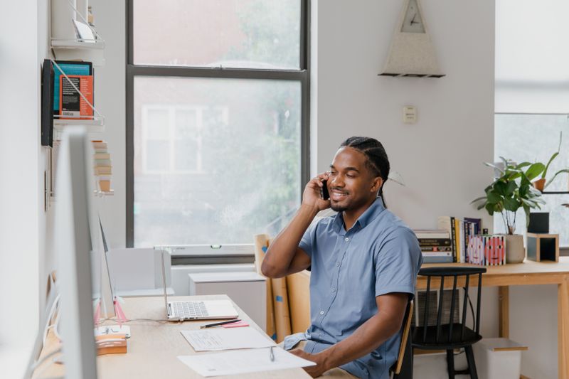 Professional man working in office, speaking on phone