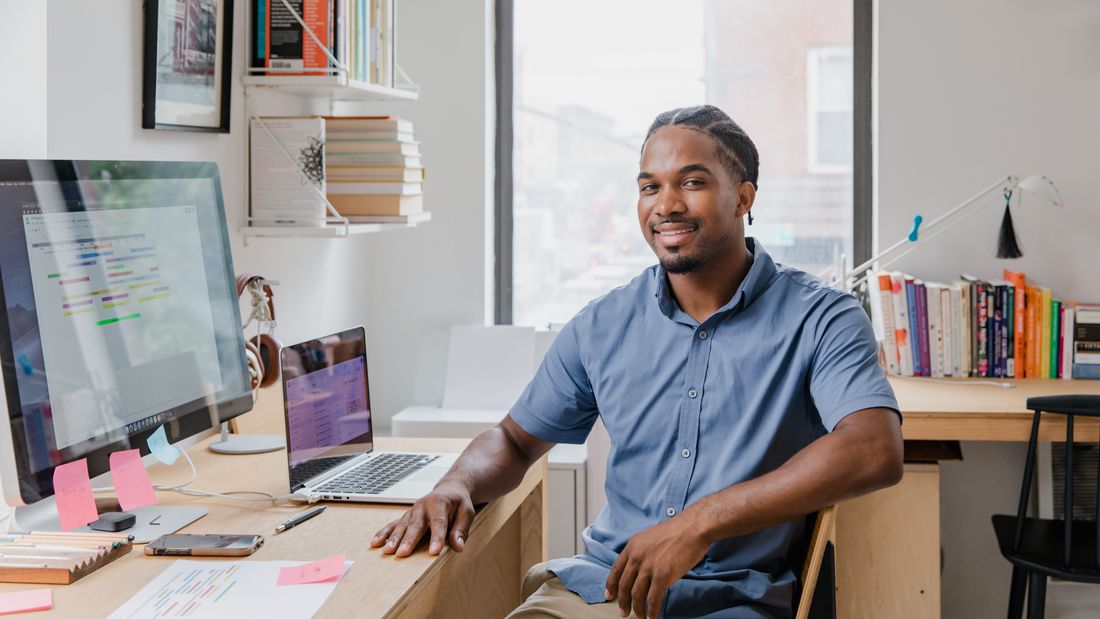 Empresario sonriente en oficina moderna — el dueño de negocio que usa Claude Code para gestionar su sistema digital