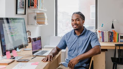 Empresario sonriente en oficina moderna — el dueño de negocio que usa Claude Code para gestionar su sistema digital