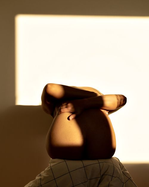 Free Minimalistic depiction of a shadow-covered back with warm lighting. Stock Photo