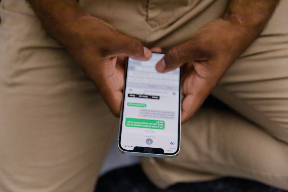 Close-up de mãos digitando mensagem de texto num smartphone