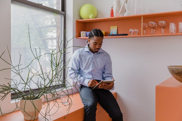 Sitting Man In Shirt Holding Tablet