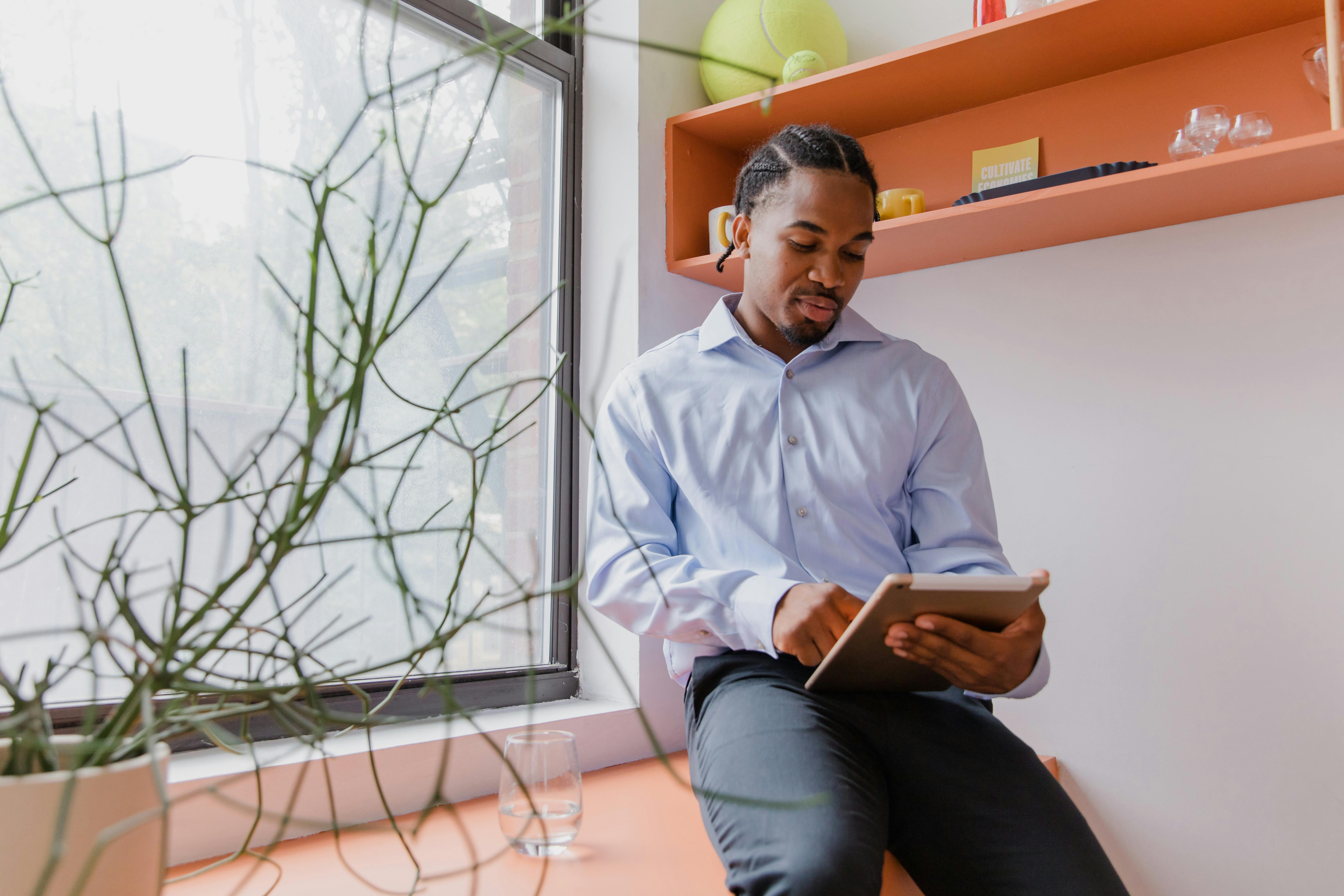 Confident businessman using a tablet in a modern office setting, focusing on work.