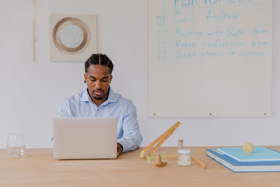 SoFi Checking vs Marcus Savings: Emergency Fund Showdown Professional man working on a laptop in a bright office with planning whiteboard.