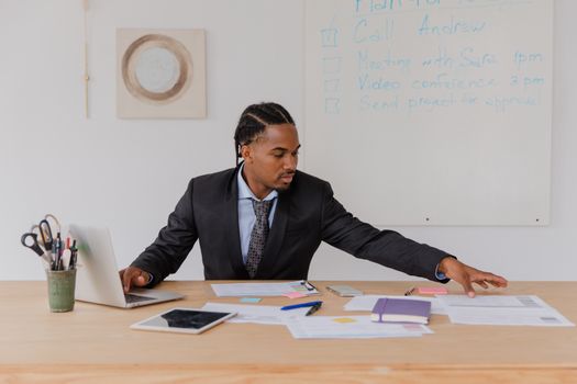 Business professional organizing documents at a desk in a modern office setting.