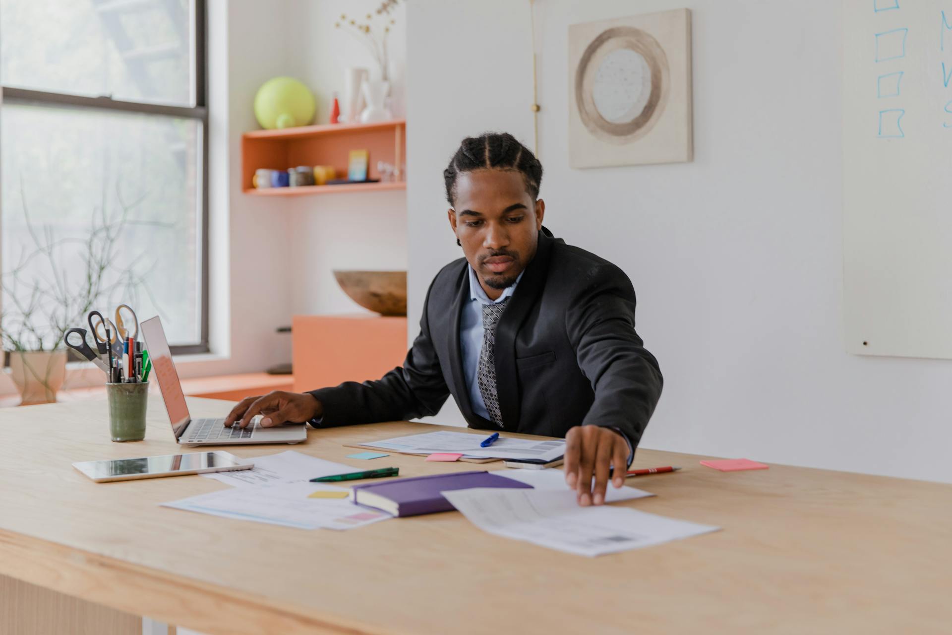 Businessman Working with Documents and Using Laptop in an Office