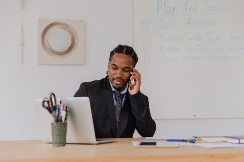 Free A businessman making a phone call in a modern office setting, working at a desk. Stock Photo