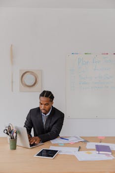 Professional businessman concentrating on laptop in modern office setting.