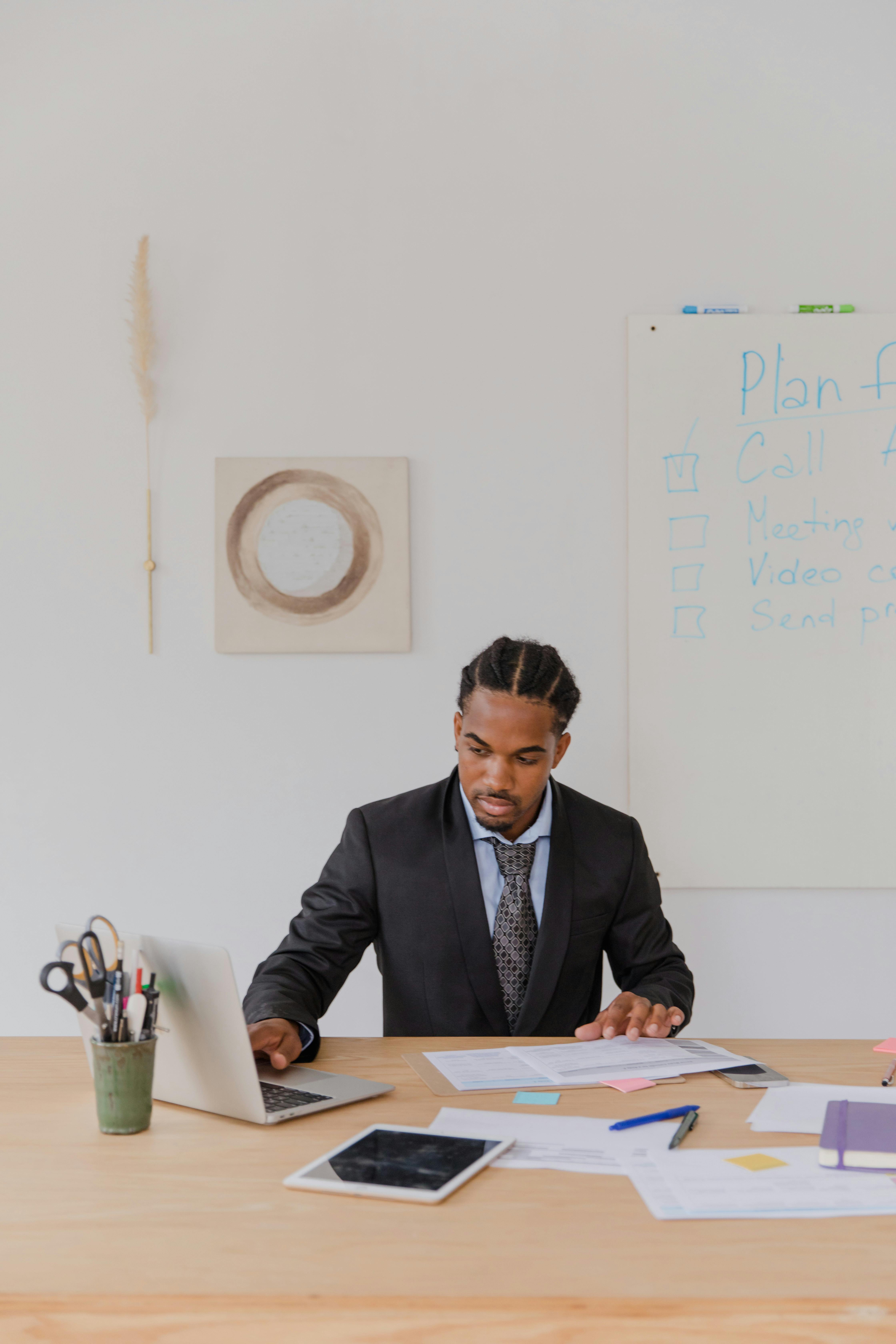Focused businessman working at desk with laptop analyzing data in an office