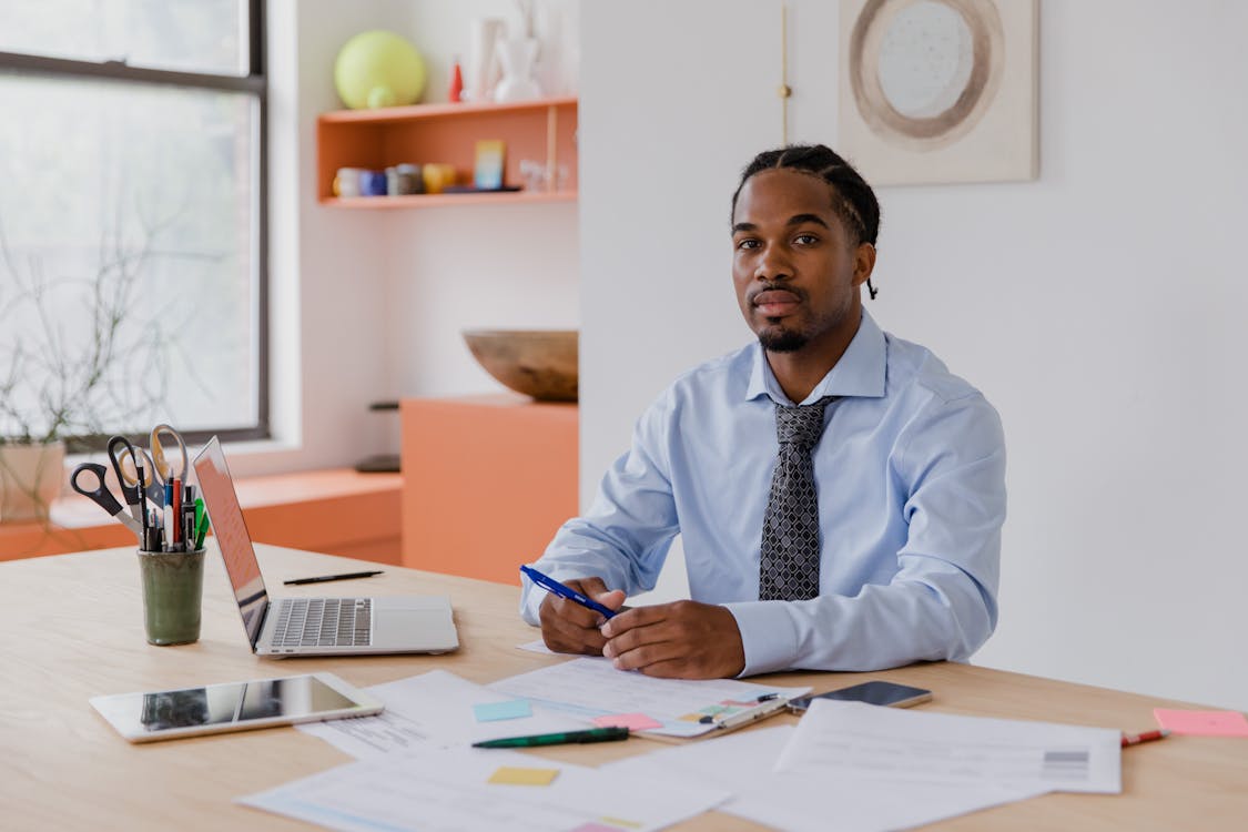 A professional man seated at a calm, organized desk in a quiet office