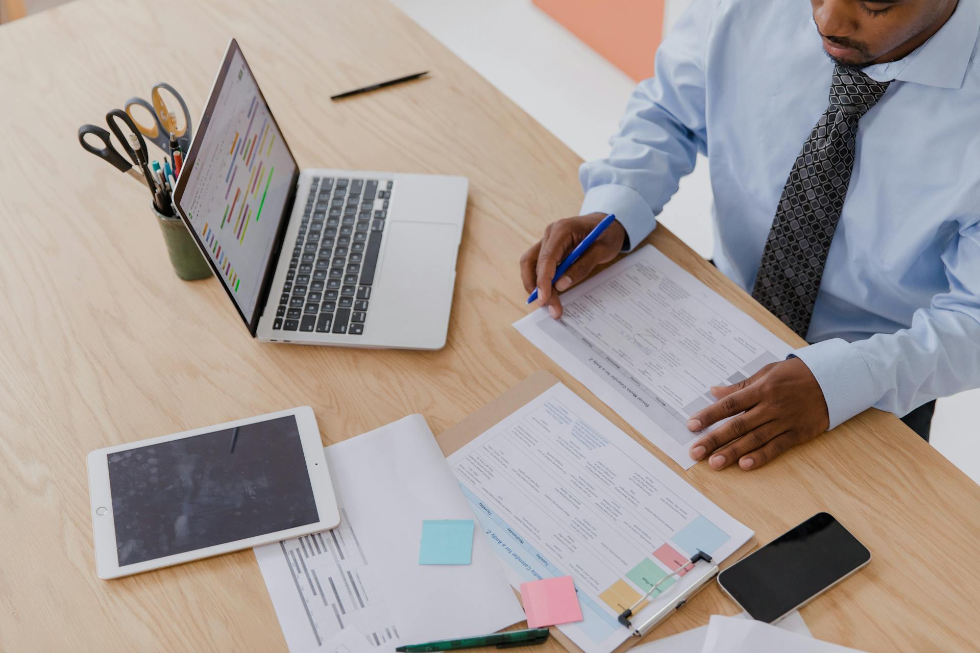 Man Sitting at Desk Working with Papers