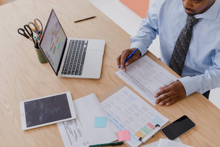 Man Sitting At Desk Working With Papers