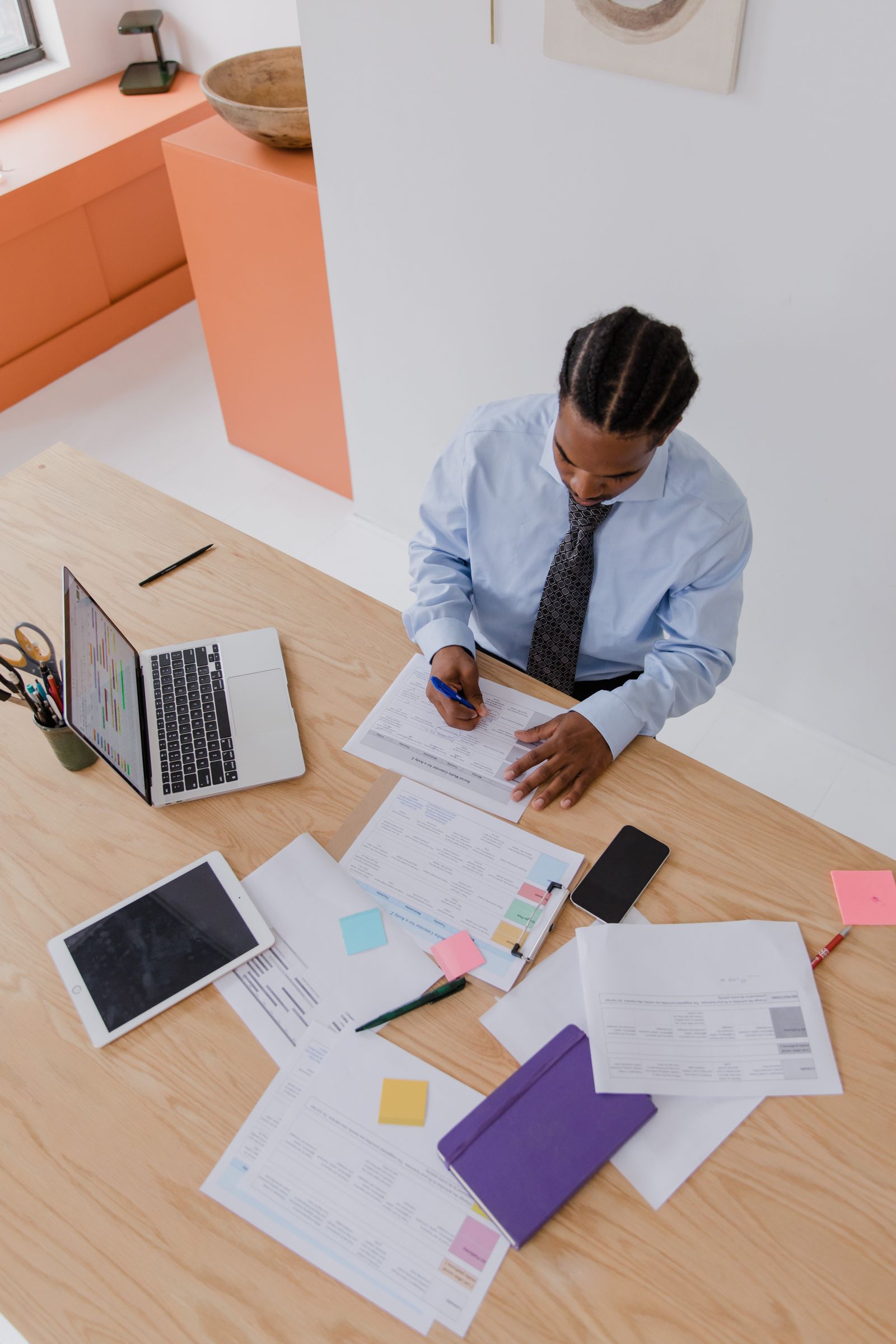 Professionnel analysant des documents de travail à côté de son ordinateur portable