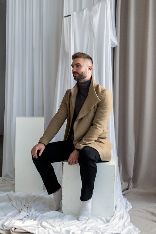Free Man in Brown Suit Jacket and Black Pants Sitting on White Chair Stock Photo