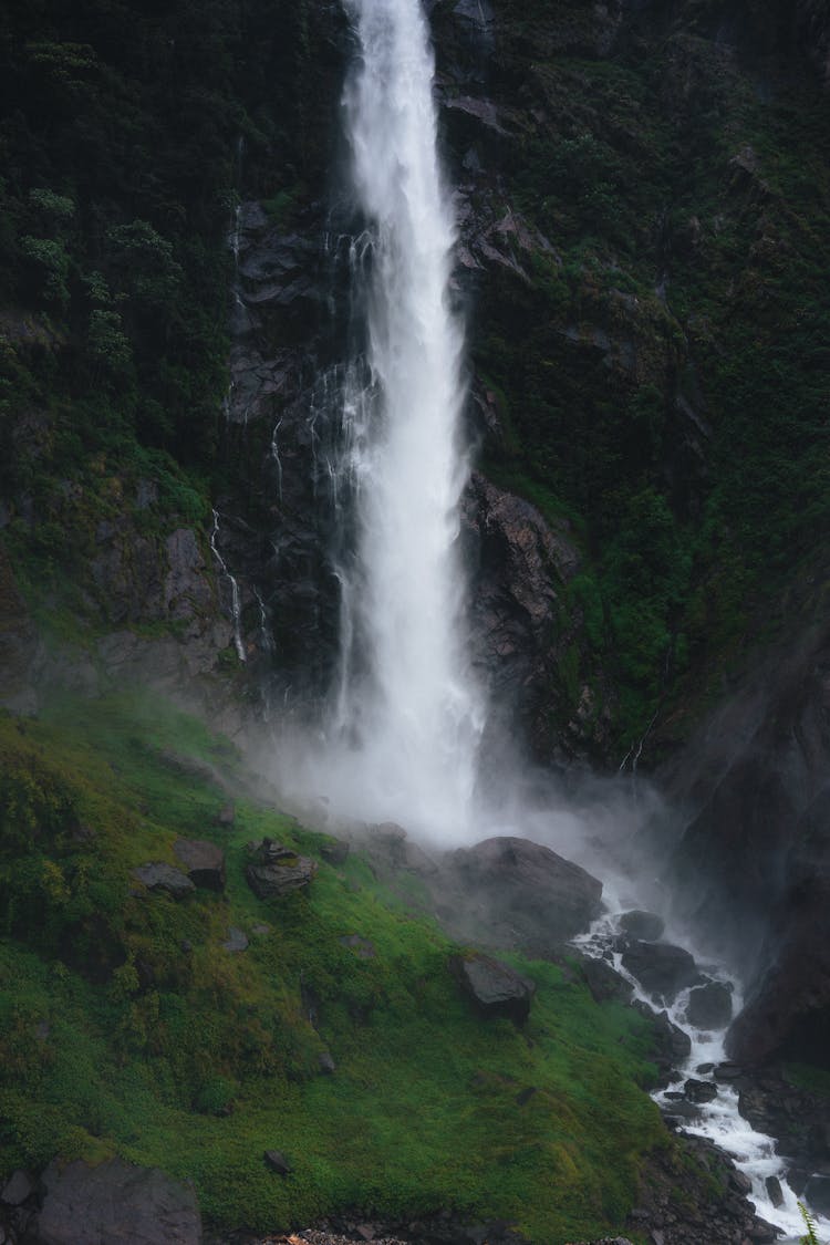 Big Waterfall In Mountain Valley Coming From High Rocky Wall