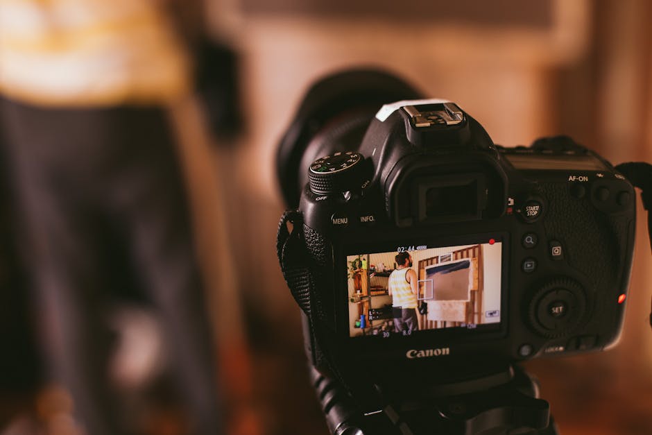 Infant Optics vs Eufy: Range Showdown Close-up view of a DSLR camera screen capturing a person in a studio setting, focusing on technology and photography.