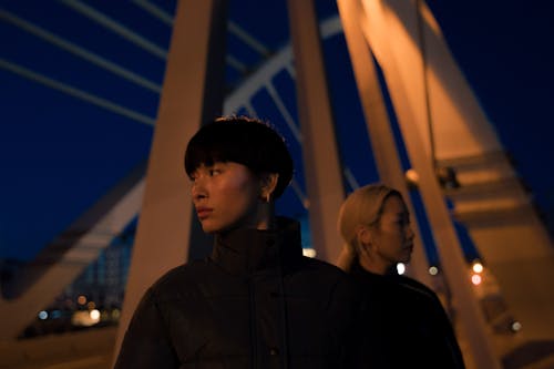 Couple Standing on Bridge at Night