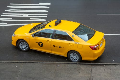 Yellow Sedan Parked on Sidewalk