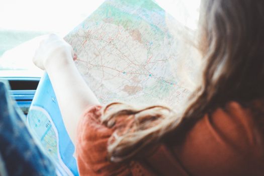 一名年轻女子正研究地图，为她的公路旅行冒险做计划