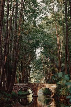 Idyllic stone bridge amidst a lush forest in Minsk, Belarus.