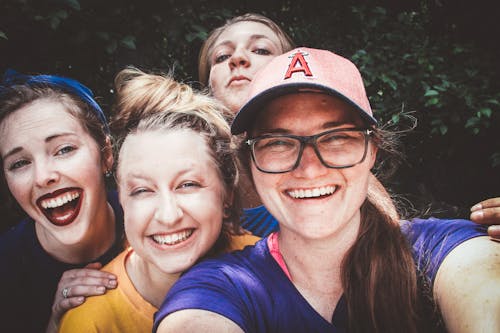 Free Four Women in Front of Green Bushes Stock Photo