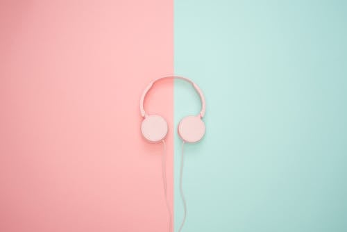 粉紅色和藍綠色的牆上粉紅色有線的耳機