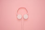 粉红色耳机在粉彩背景下，呈现出完美的现代时尚外观