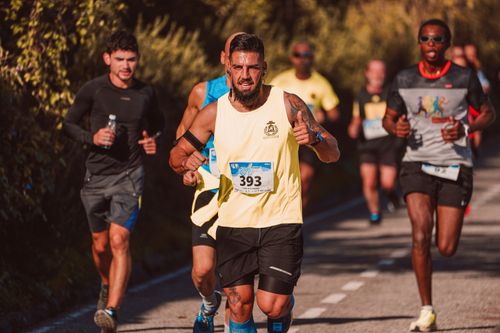 Free Athletes competing in an exhilarating marathon on a sunny day, showcasing determination and vigor. Stock Photo