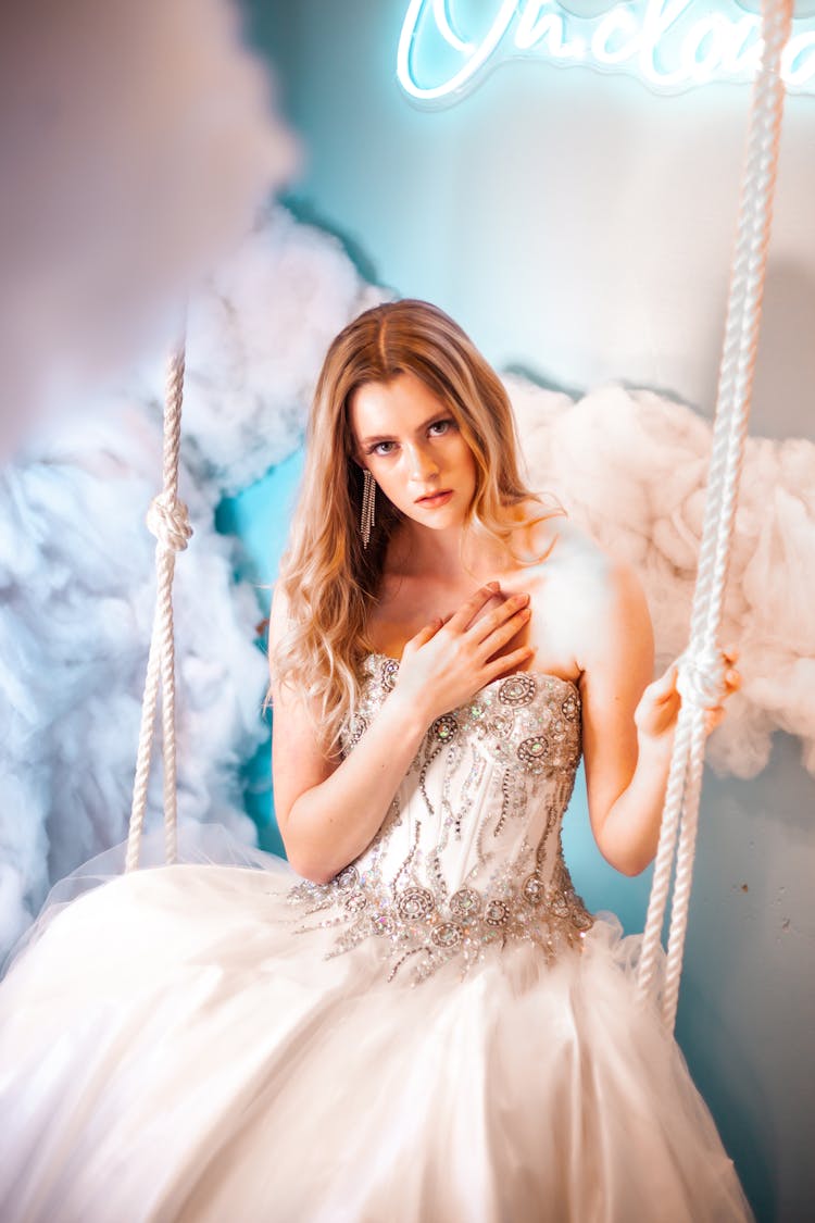 Woman In A Ball Gown Sitting On A Swing