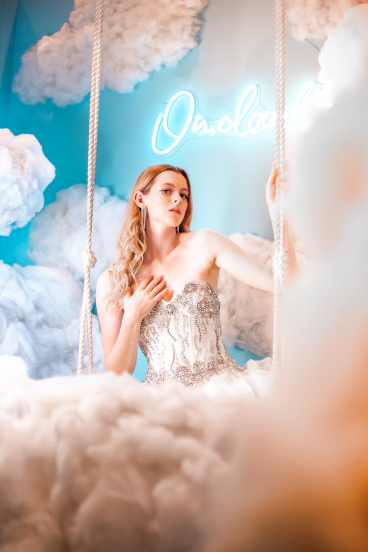 Woman Sitting On A Swing In Beautiful Dress And Heaven Decoration