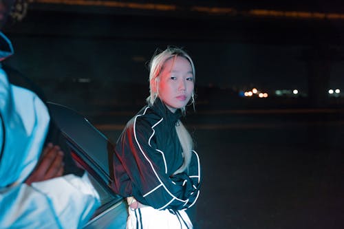 A Woman Standing Near the Car During Night Time