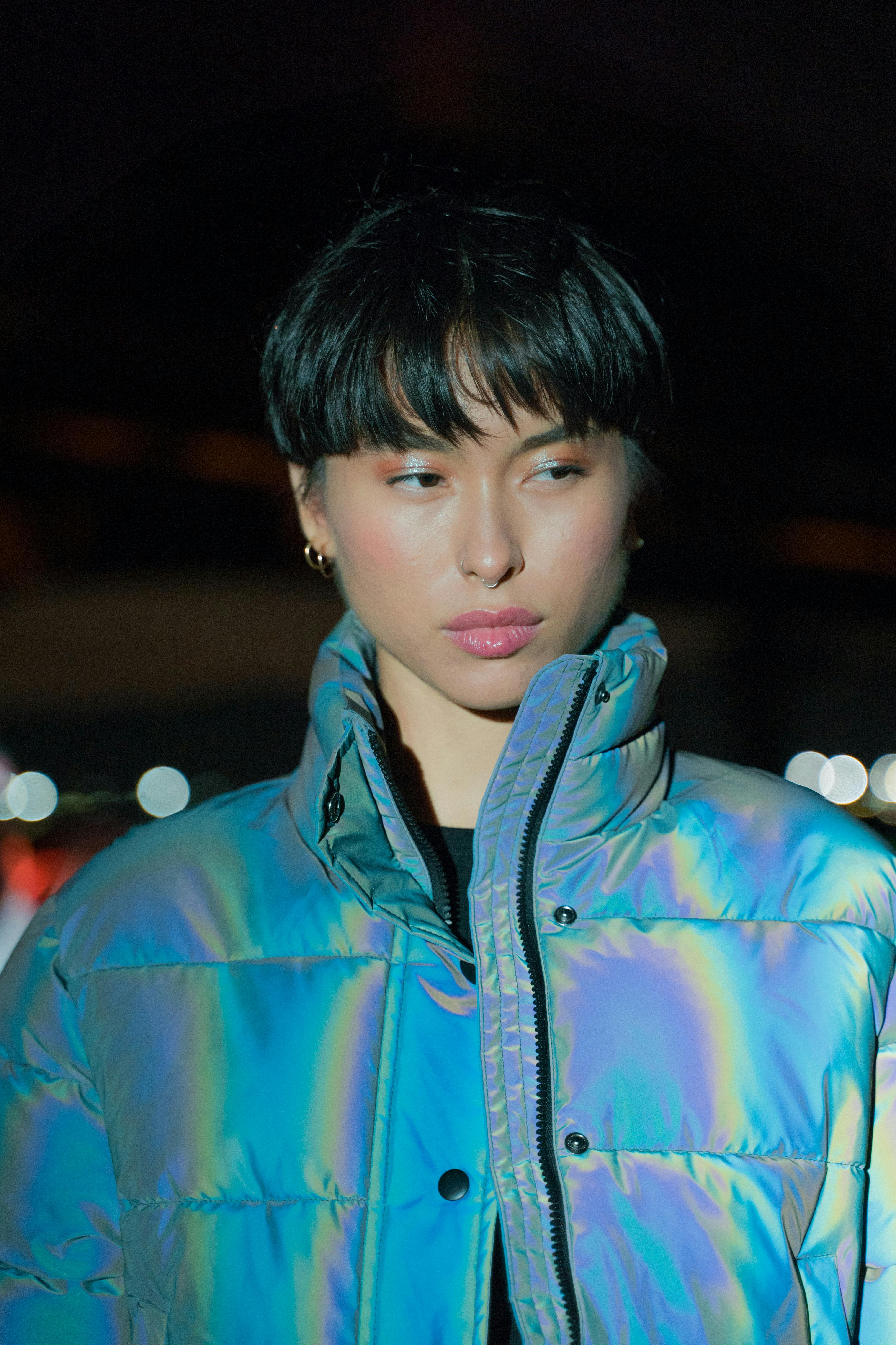 a pretty woman with short hair wearing blue shiny jacket