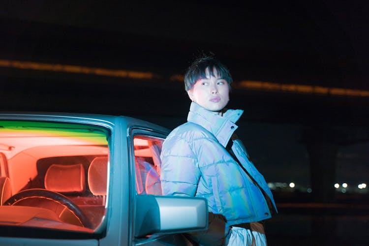 A Woman In Blue Jacket Leaning On Blue Car 