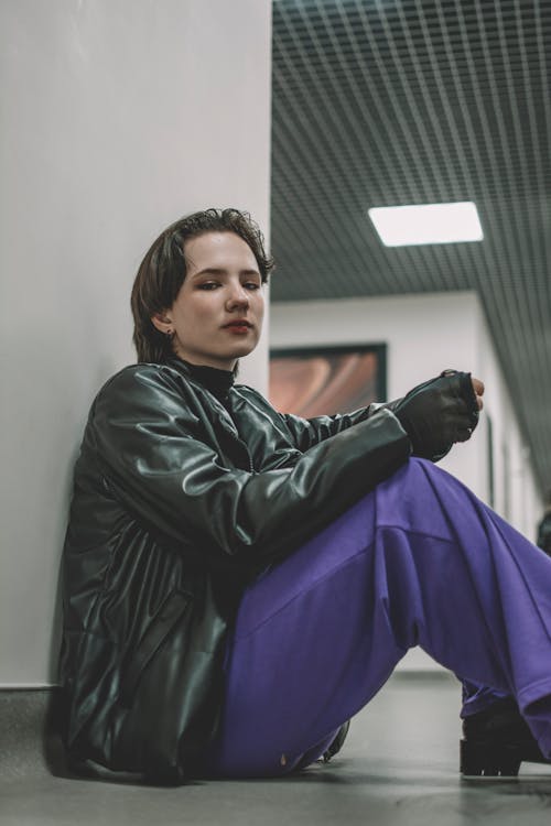 Woman in Black Leather Jacket Sitting on the Floor