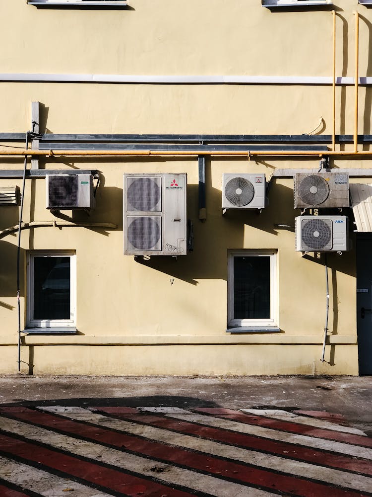 A Concrete Building With Outer Units Of Split Type Aircons Mounted On Wall