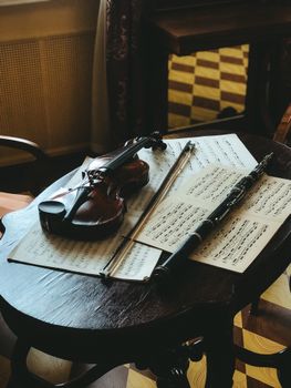 Violin and sheet music on a wooden table, creating a vintage musical atmosphere.