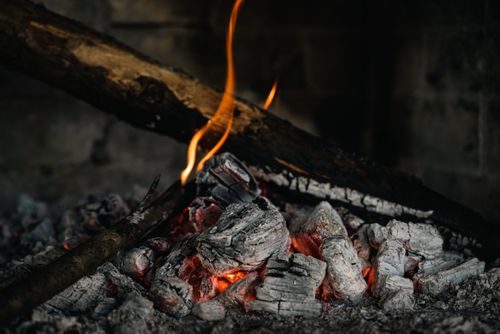 Hot embers under burning firewood — photo by Chris F on Pexels