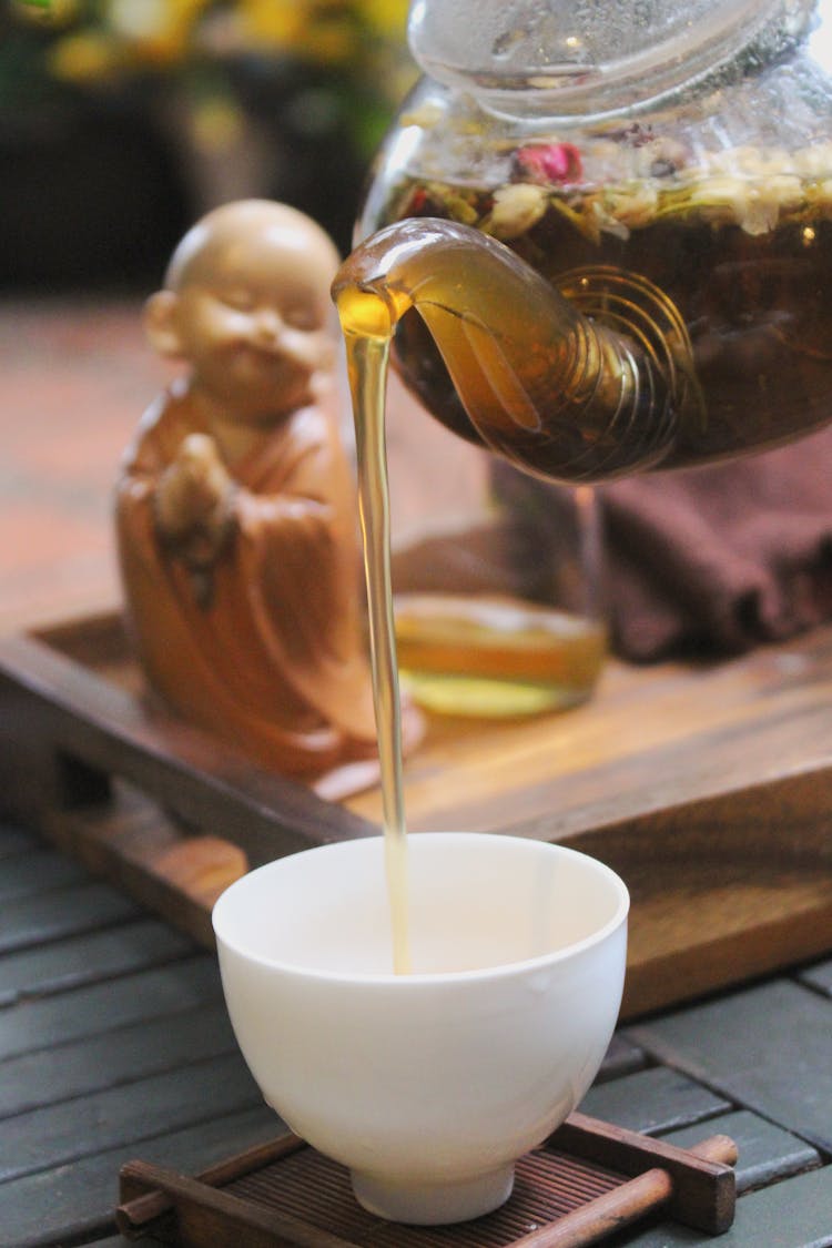 Tea Poured From A Teapot Into A Cup