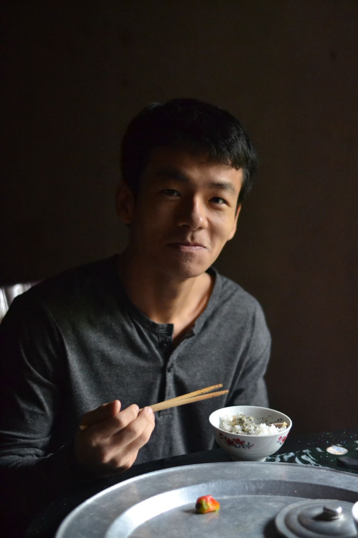 Person enjoying a steaming bowl of rice with chopsticks