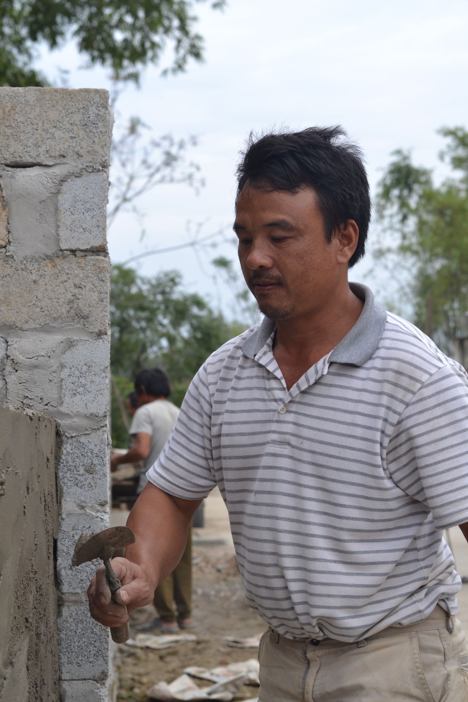 Masonry contractor applying mortar while building a brick wall on a construction project