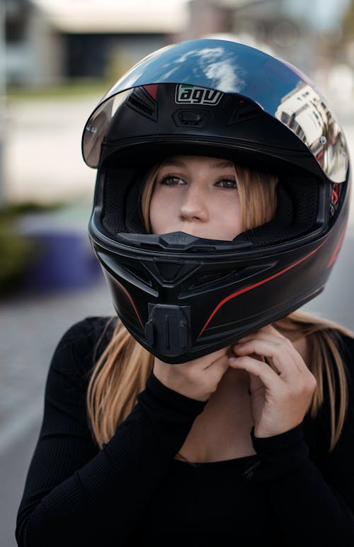 Woman Putting on a Black Helmet