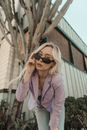 Girl with Sunglasses Bending into Camera