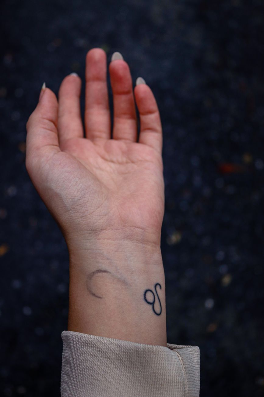 Detailed close-up of a small delicate temporary tattoo design on wrist showing longevity