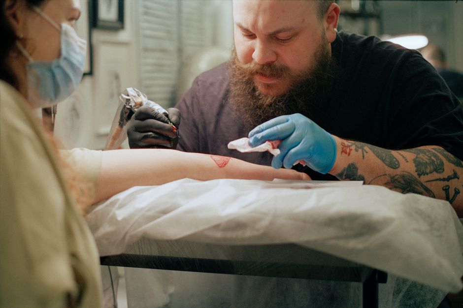 Tattoo Artist wearing fresh gloves practicing universal precautions at a clean workstation Tattoo Artist wearing fresh gloves practicing universal precautions at a clean workstation