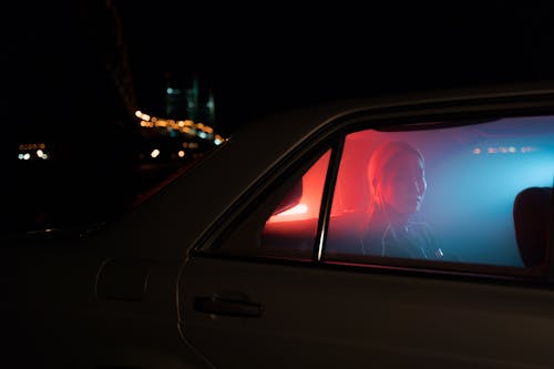 Woman Sitting at the Back Seat of a Car