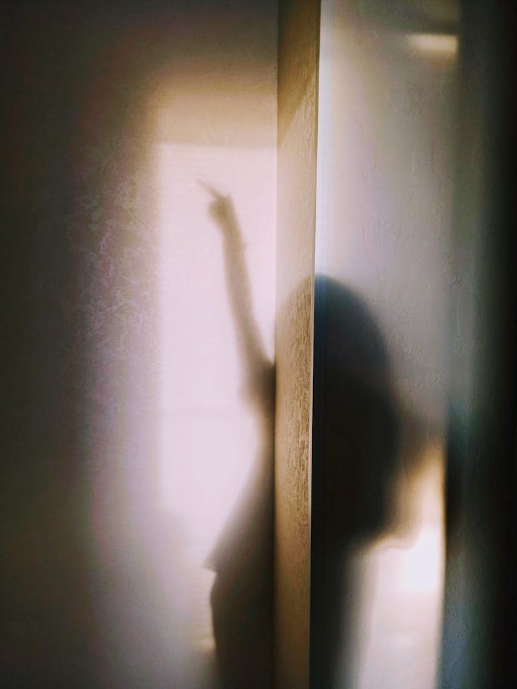 Silhouette Of Woman Behind Transparent Curtains 