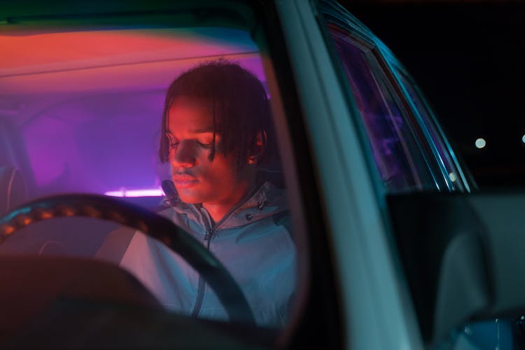 A Man Sitting At The Driver Side Of A Car