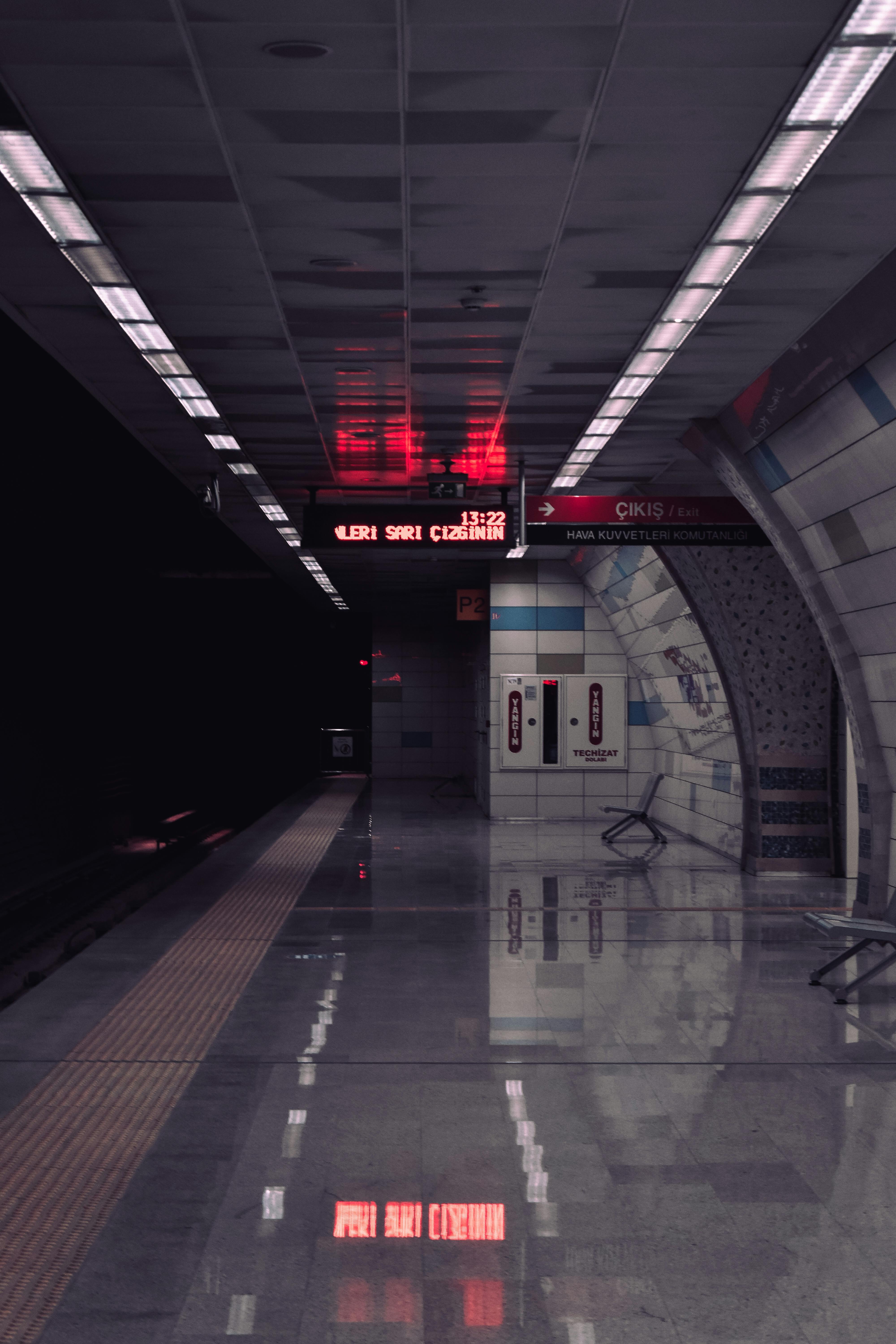 A deserted modern subway station with sleek architectural design and illuminated signs