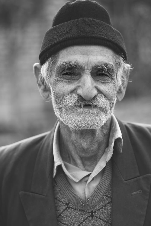 Free Grayscale portrait of an elderly man with a beard, wearing a hat in Hamedan, Iran. Stock Photo