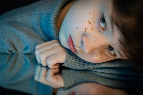 Woman in Green Sweater With Glitters on Face